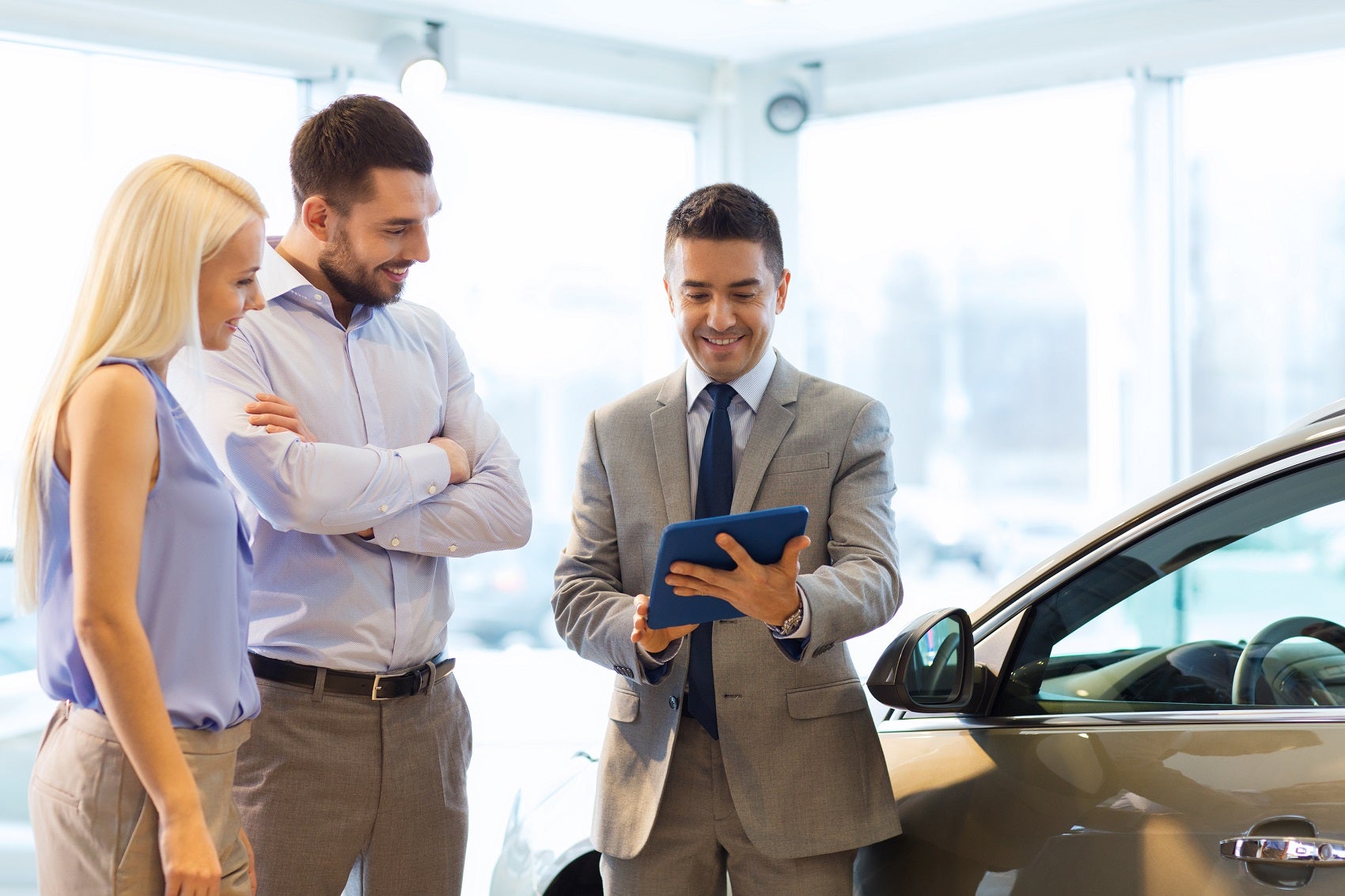 Sales manager showing paperwork to customers in showroom